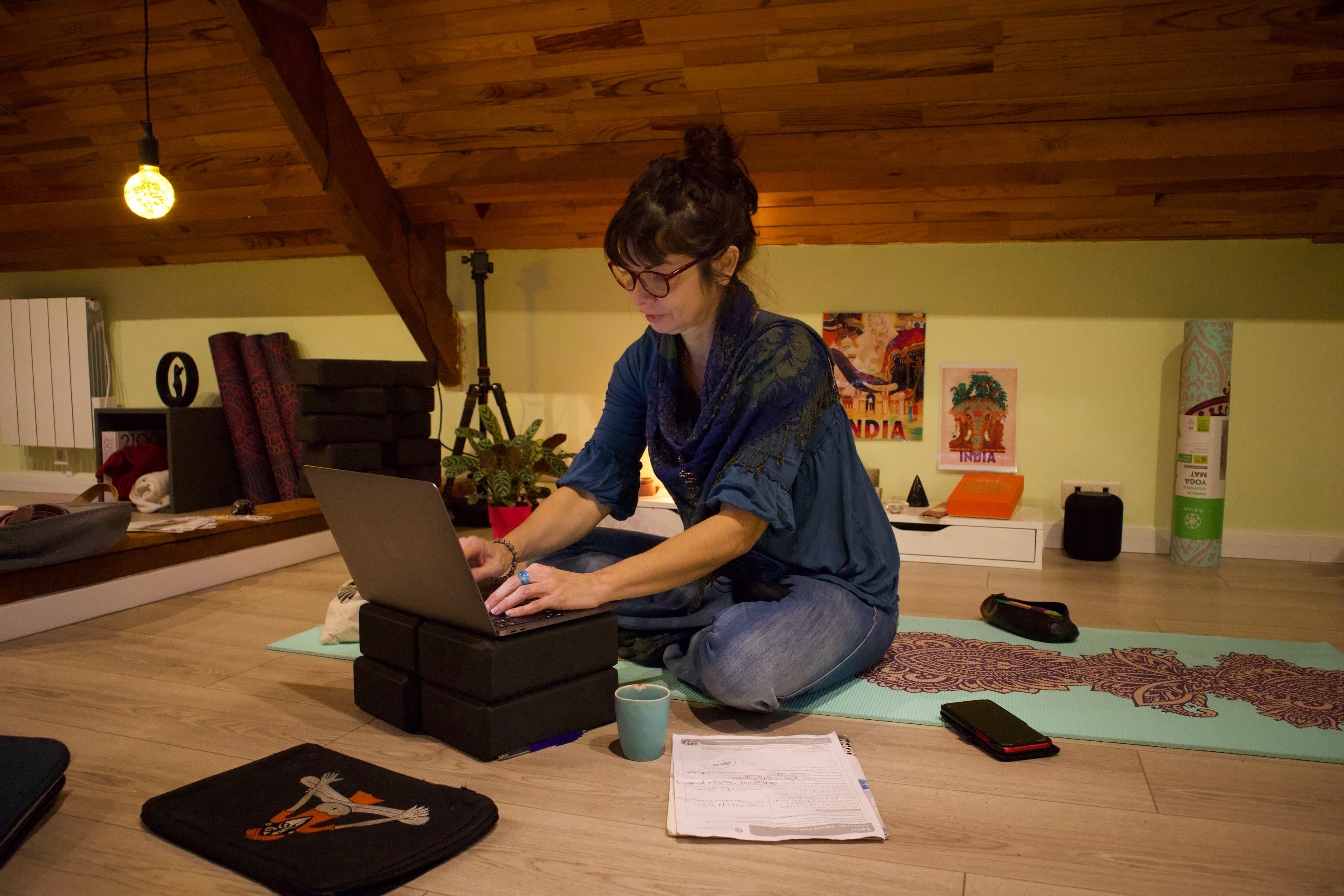 Professeure de yoga préparant un cours en ligne sur son ordinateur portable.